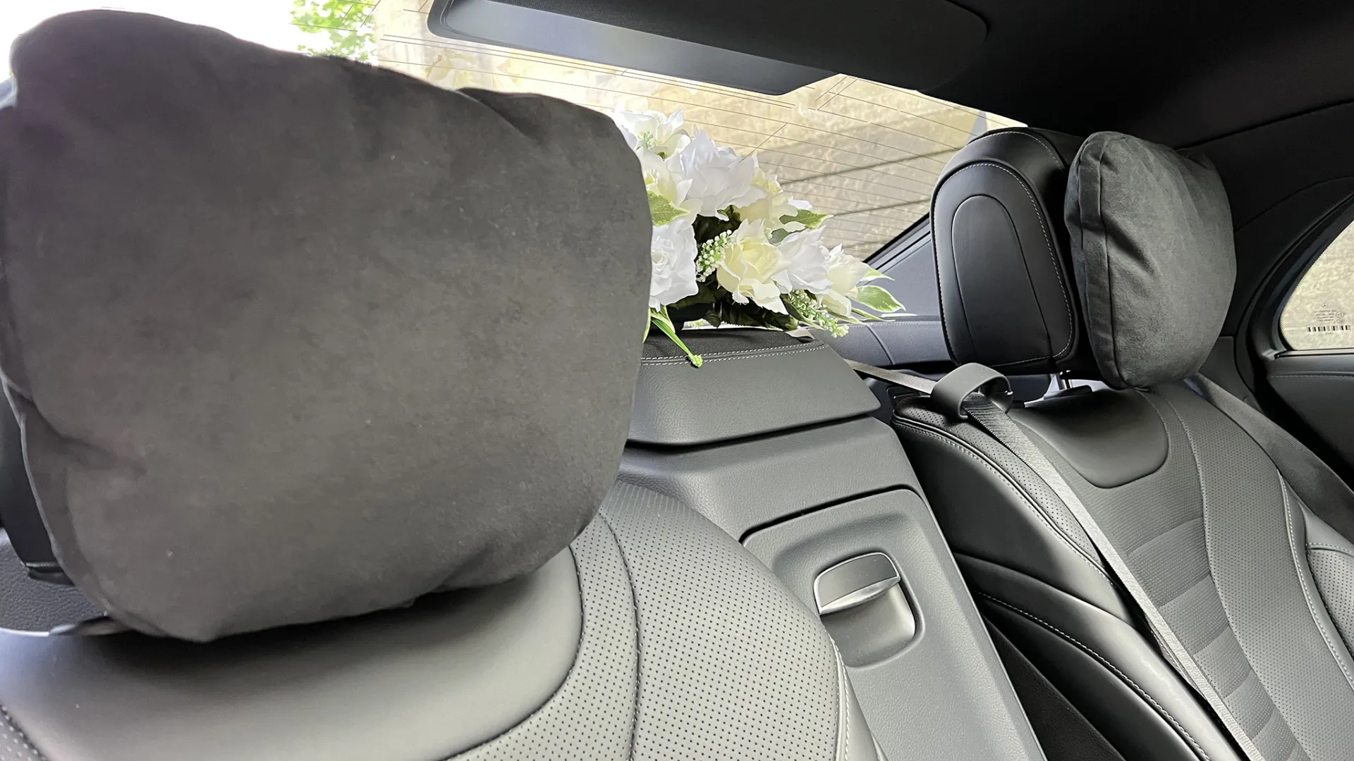 Rear interior seats inside Mercedes with posy of white flowers on the rear parcel shelf