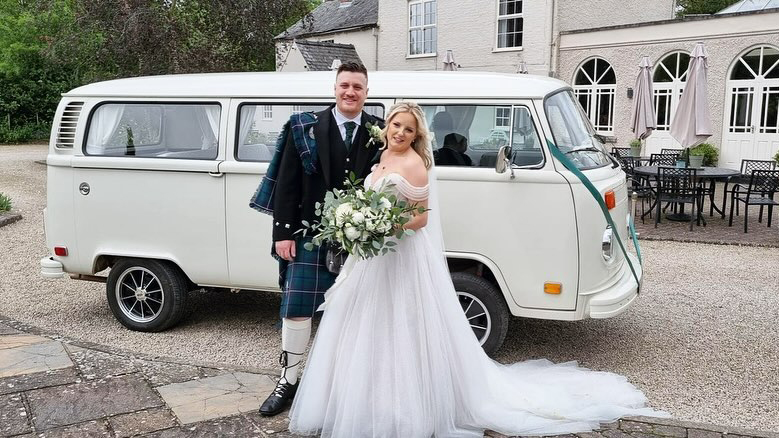 Bride and Groom standing in front of a classic VW Campervan