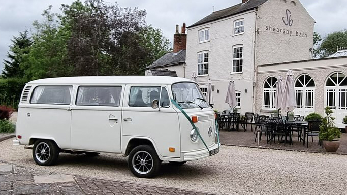 Classic VW campervan with wedding ribbons parked in front of Shearsby Bath Wedding Venue in Leicetershire