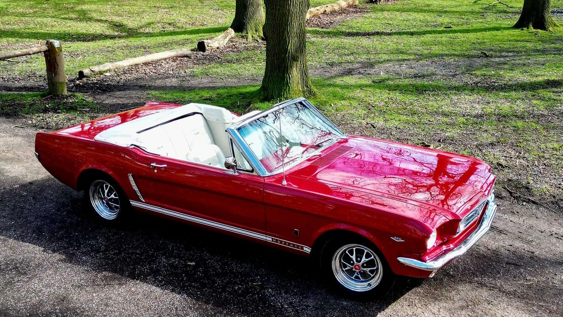 Aerial view of classic Ford Mustang in red showing white leather interior