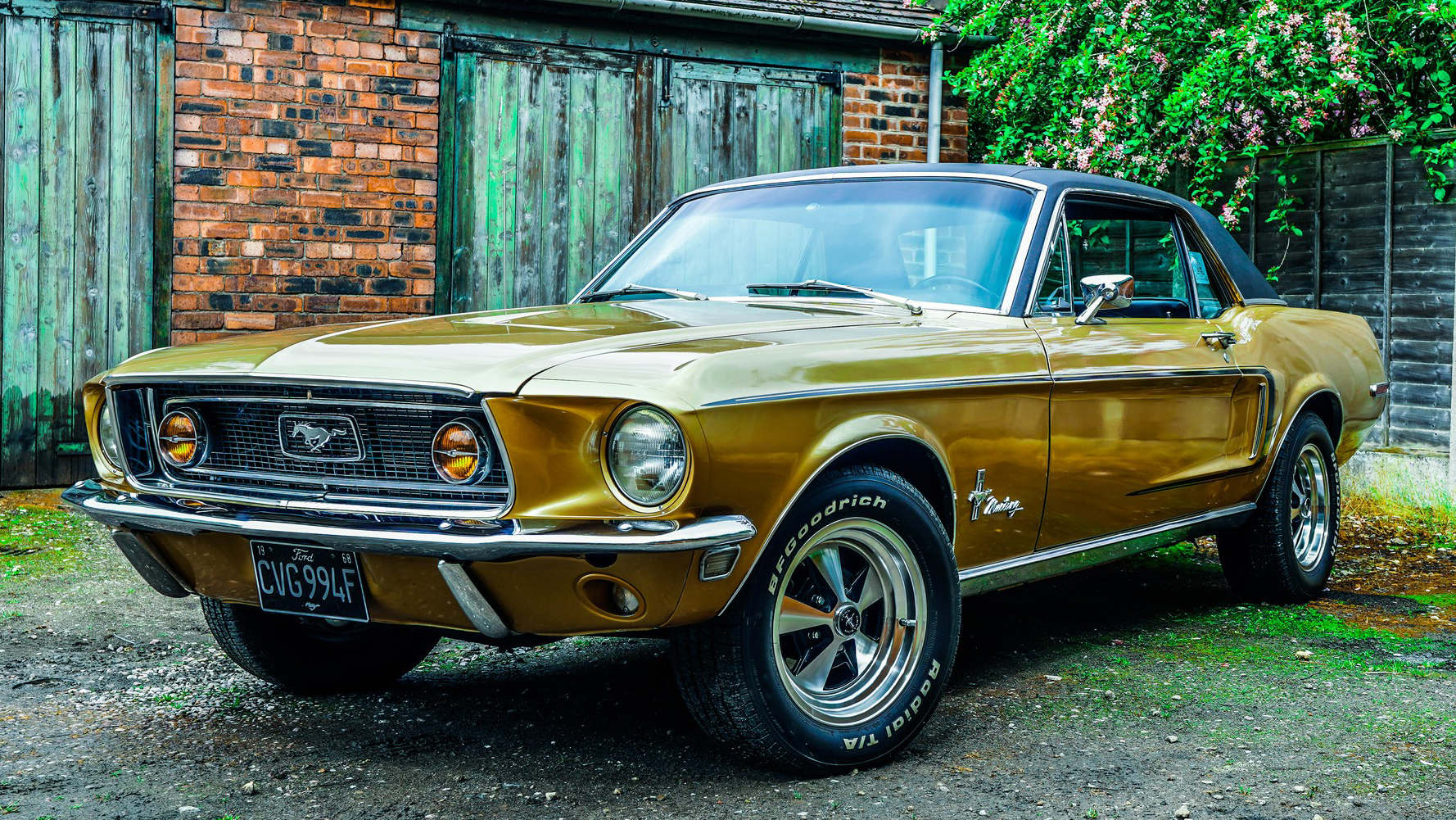 Classic Ford mustang parked in front of a rustic barn