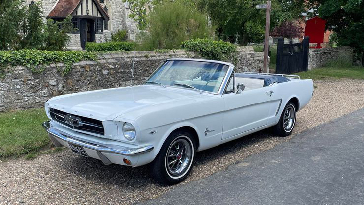 Classic Ford Mustang in White parked in front of a church