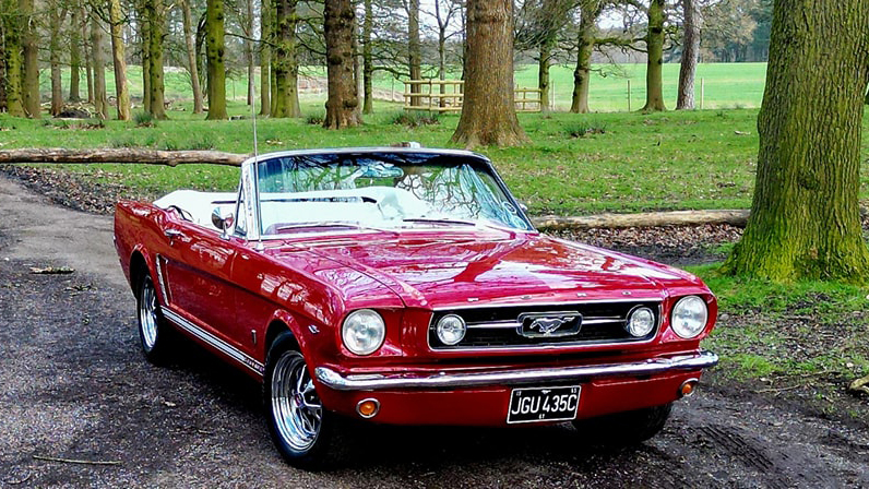 Convertible red Classic Ford Mustang with roof down