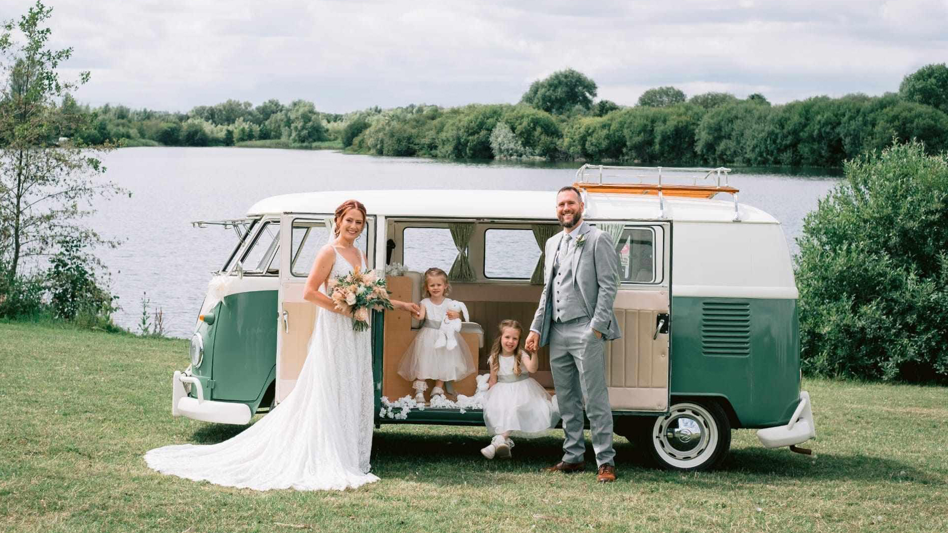 Bride, Groom and their 2 daughters posing in front of a classic VW Campervan in Green and White