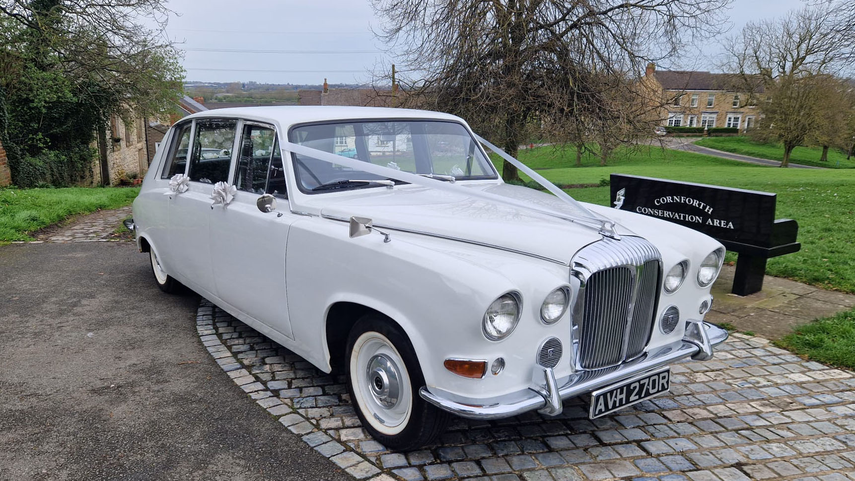 Right front side view of a classic daimler limousine in white