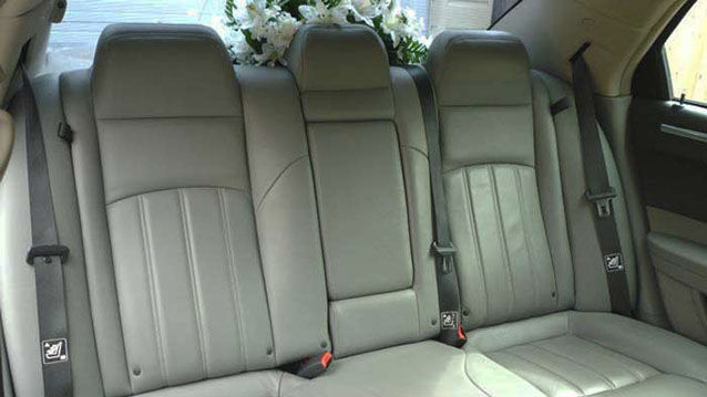 Grey leather rear interior seats dedcorated with white flowers on the parcel shelf.