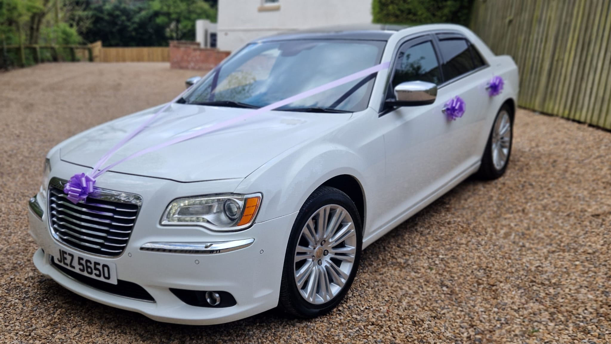 White 300c chrysler car with light purple ribbons and bows