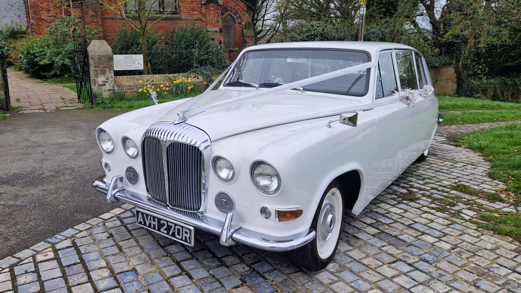 White Classic Daimler Limousine decorated with white wedding ribbons