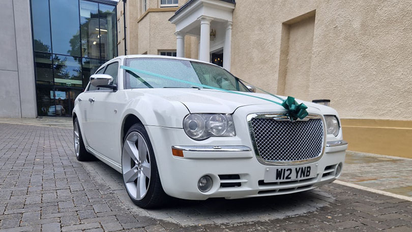 White Chrysler 300c Saloon Car decorated with blue ribbons and bows