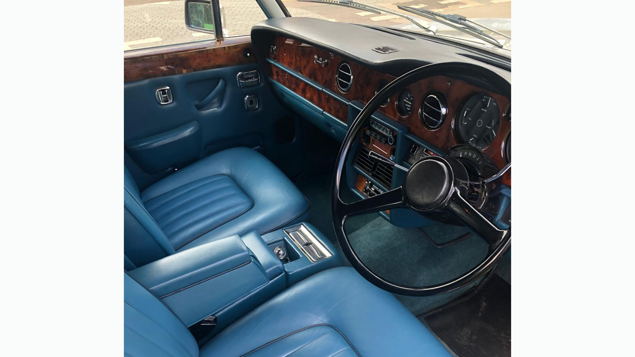 front interior of blue leather with wooden dashboard