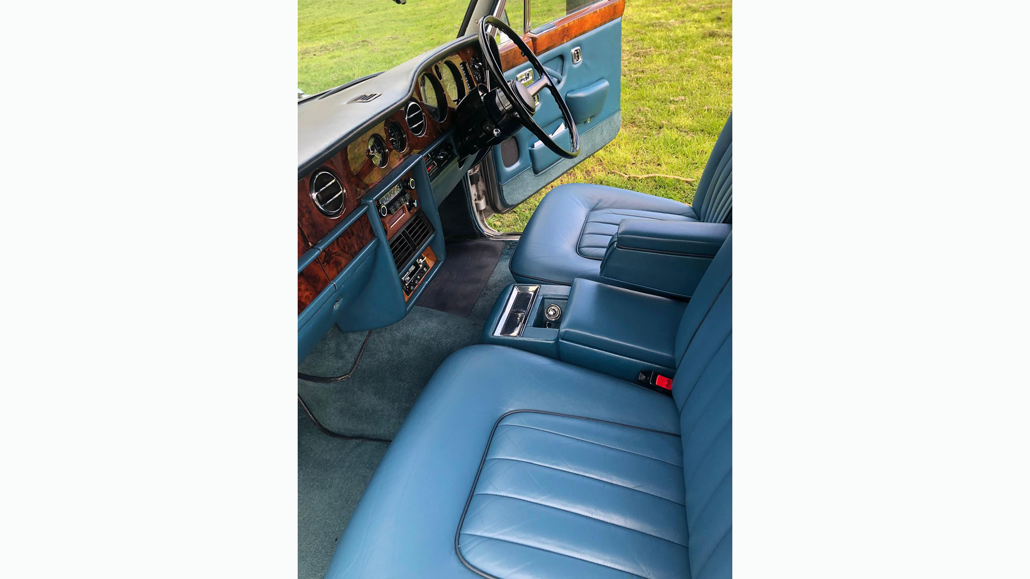 front interior of blue leather with wooden dashboard