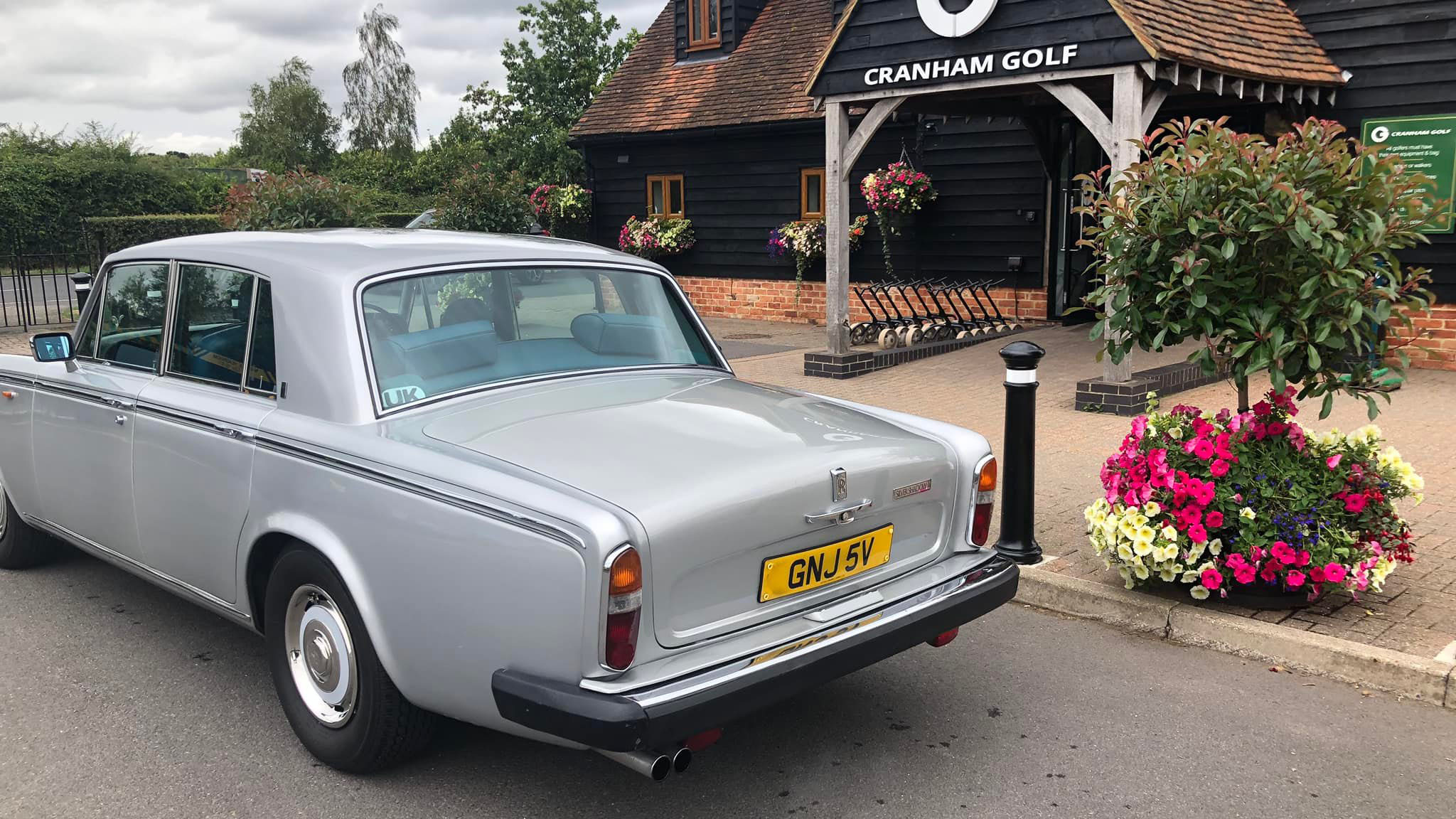 rear view of a classic Rolls-Royce Silver Shadow in silver at a wedding venue