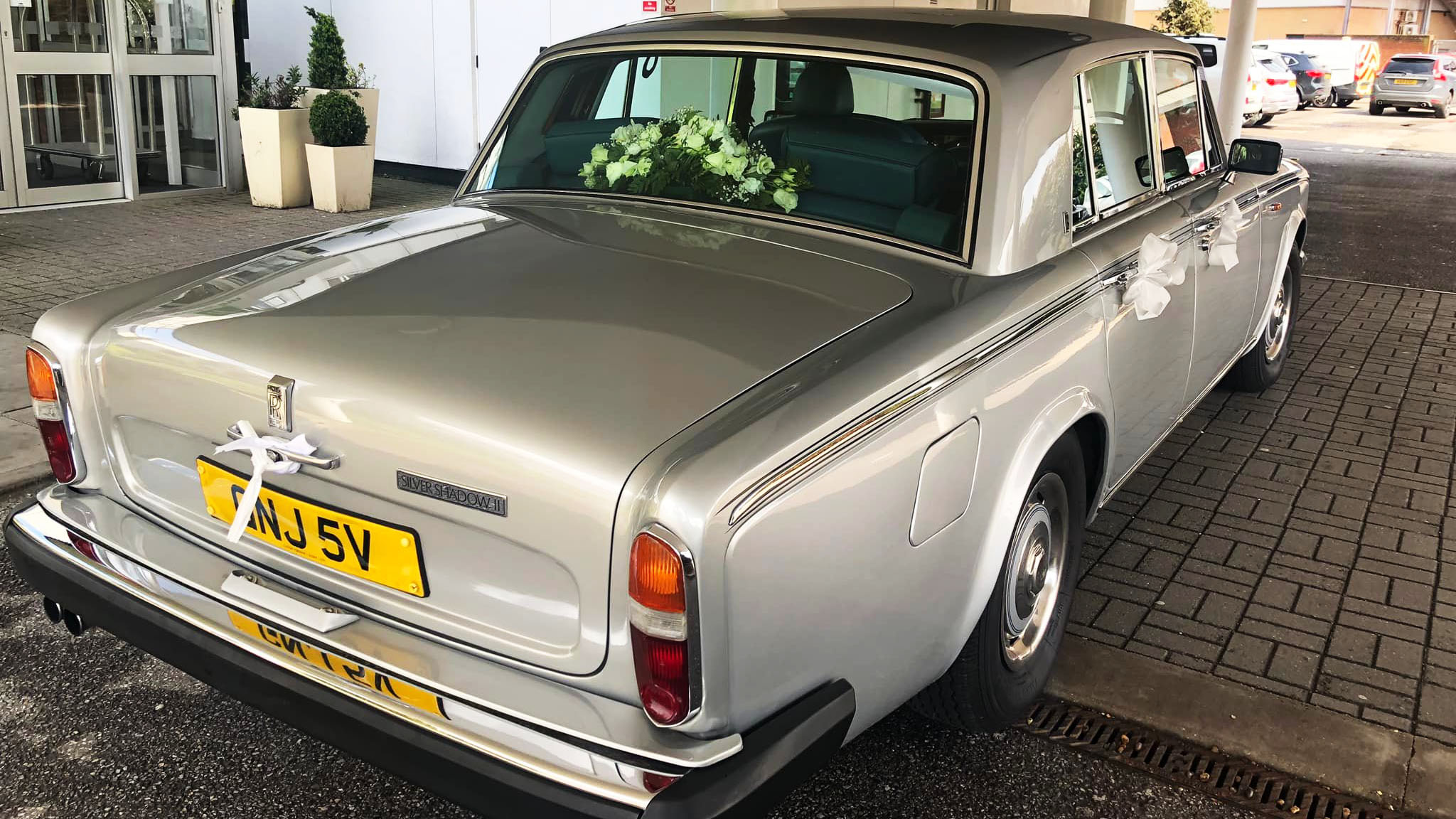 rear view of a classic Rolls-Royce Silver Shadow with flowers on its parcel shelf