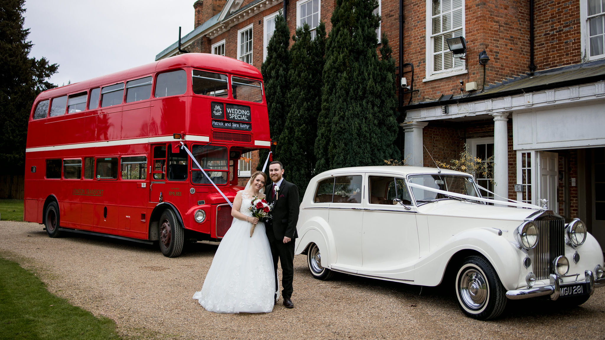 Red Double decker Routemaster with a classic Car with Bride and Groom posing for photos between both vehicles