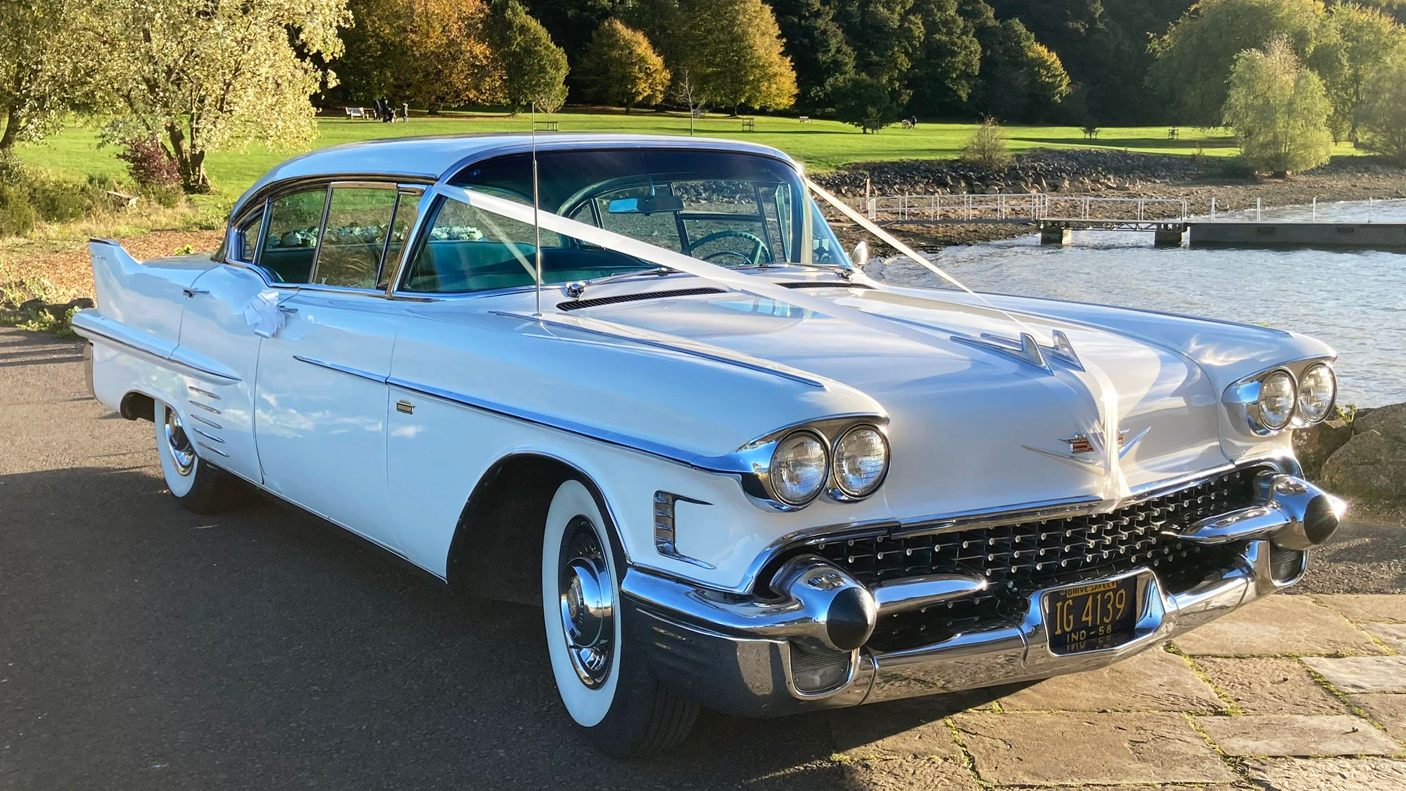 Classic white american Wedding Car with white ribbons