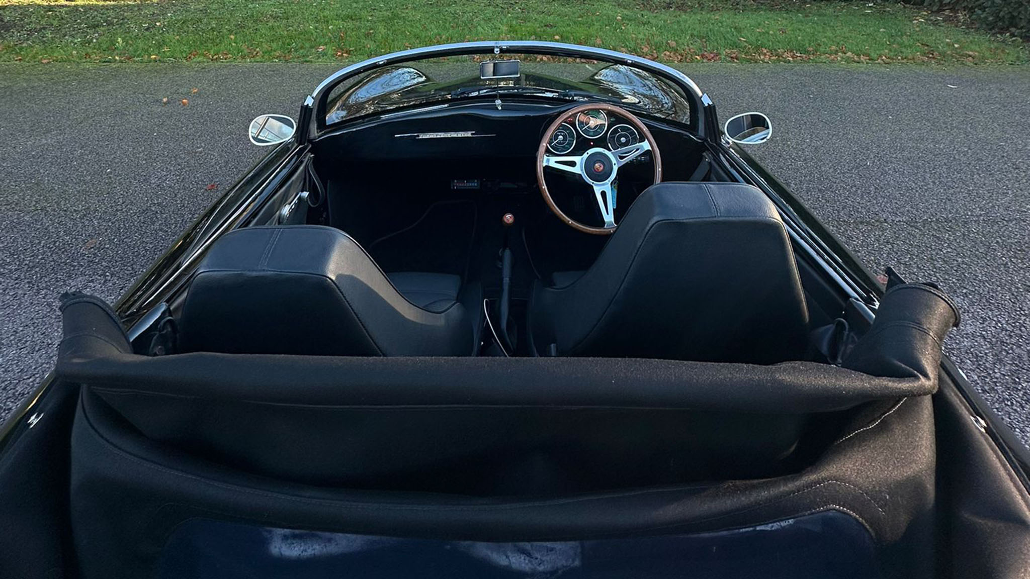 Aerial view of Black Porsche with convertible roof down showing black leather interior