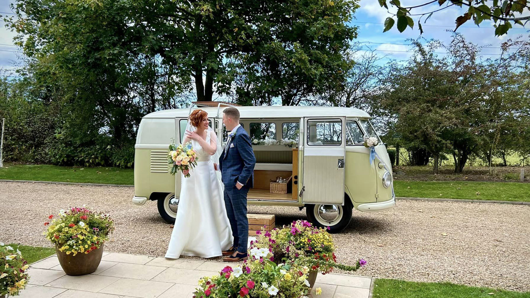 Bride and groom in front of a classic campervan