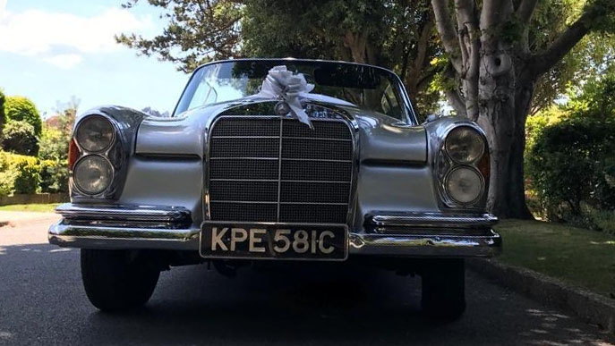 Front view of a classic Mercedes with large Chrome Grill and twin headlights