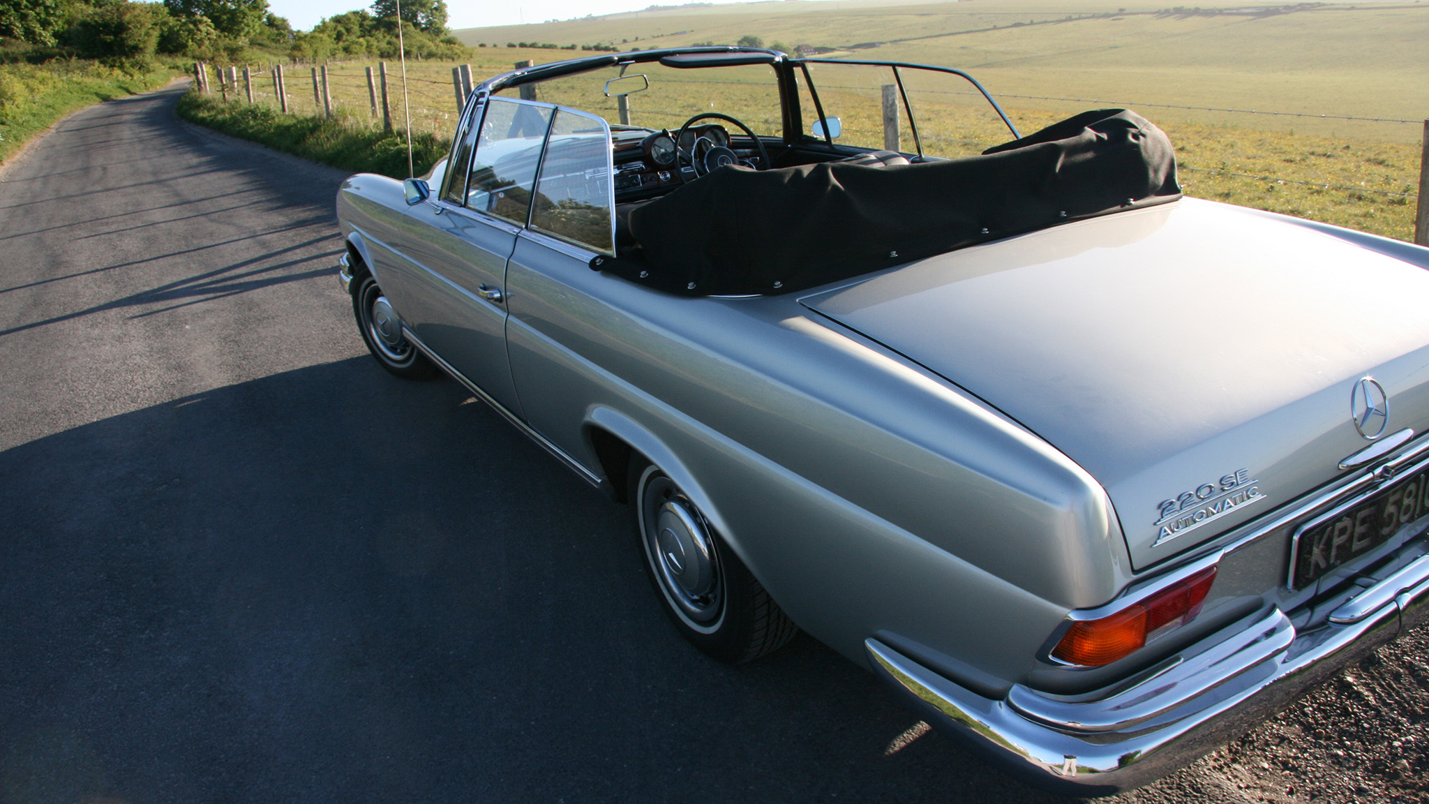 Rear view of classic silver Mercedes with convertible soft top roof open