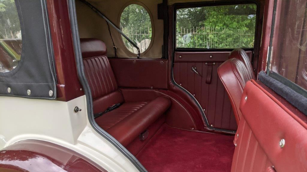 rear passenger door open showing burgundy carpet and leather seats