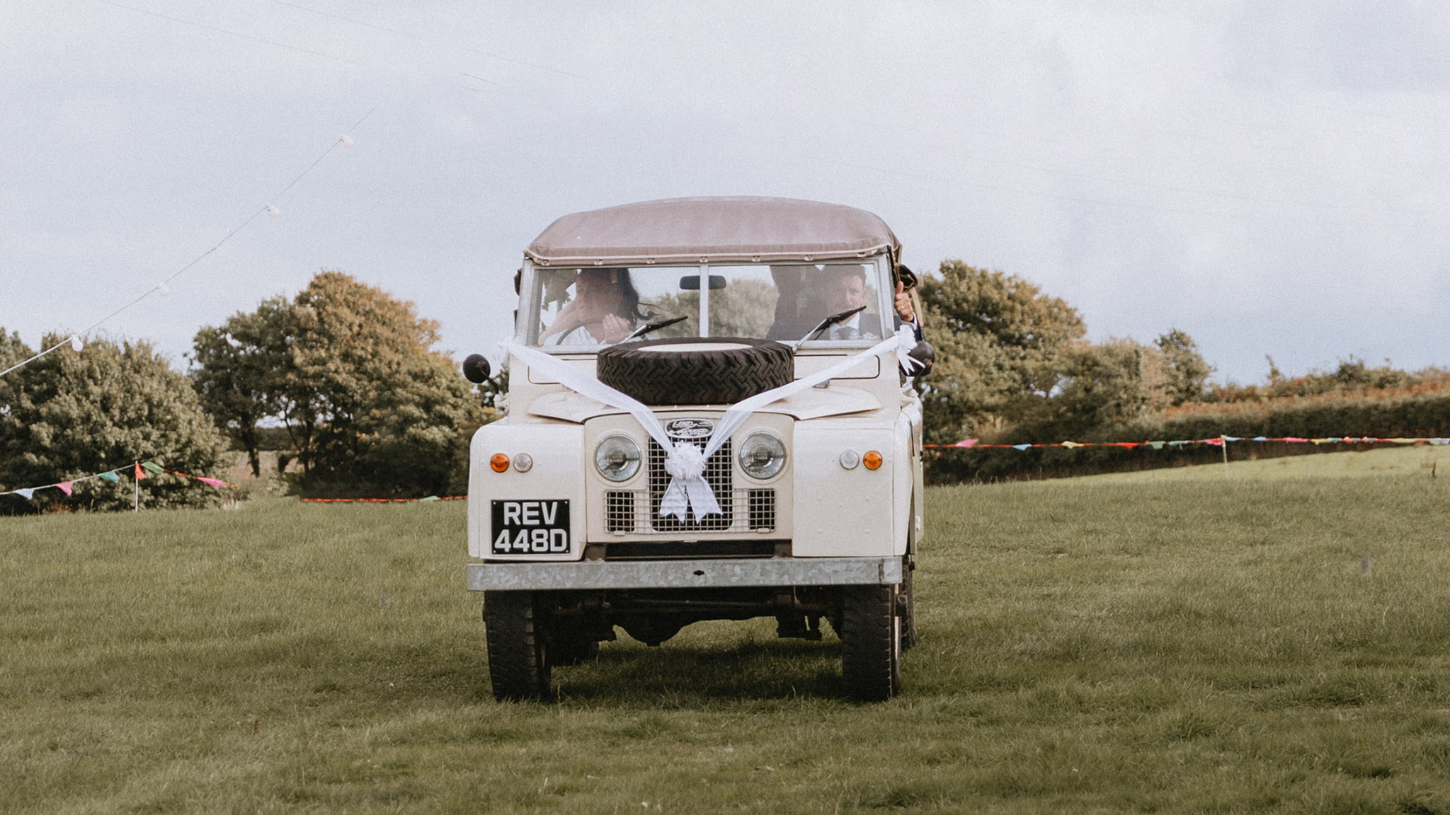 front view of Classic Land Rover with white ribbons and bows