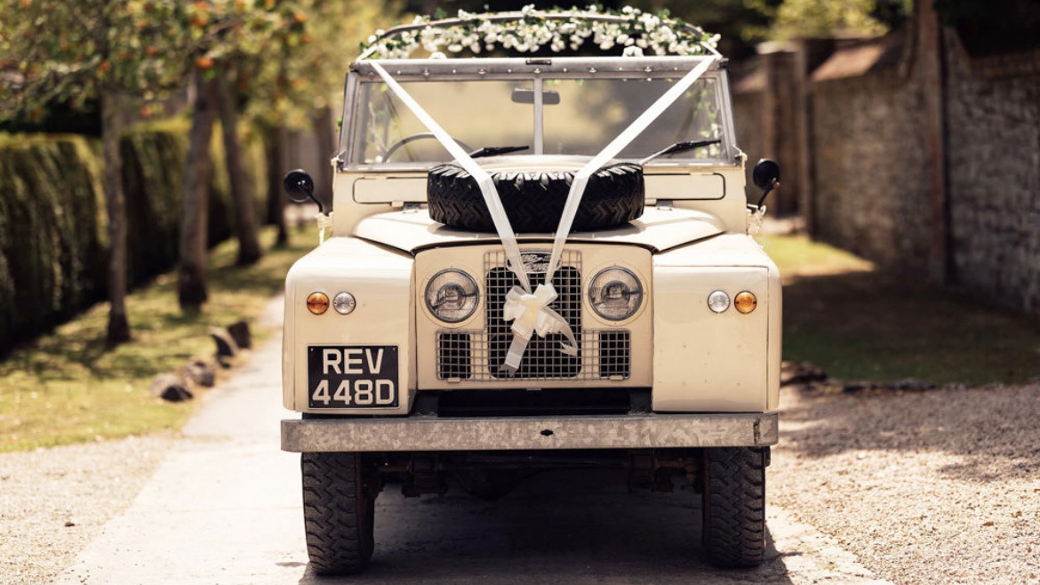 front view of Classic Land Rover with white ribbons and bows