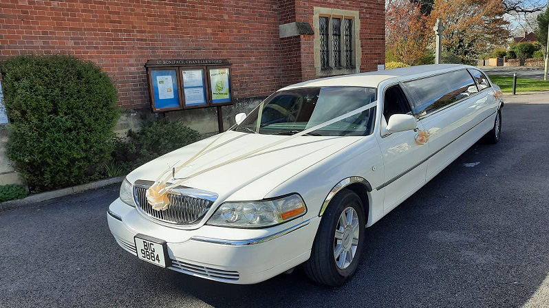 Ivory ribbons and bows on a white stretched limousine