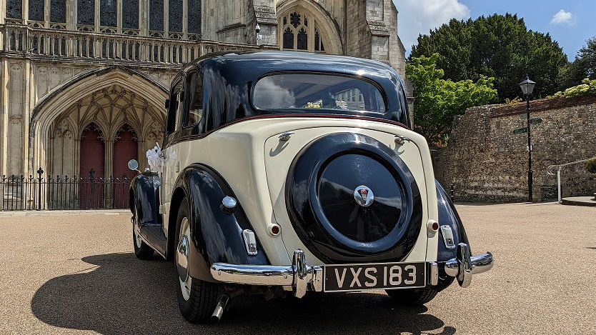 rear view of ivory and black Rover p3 in front of a cathedral