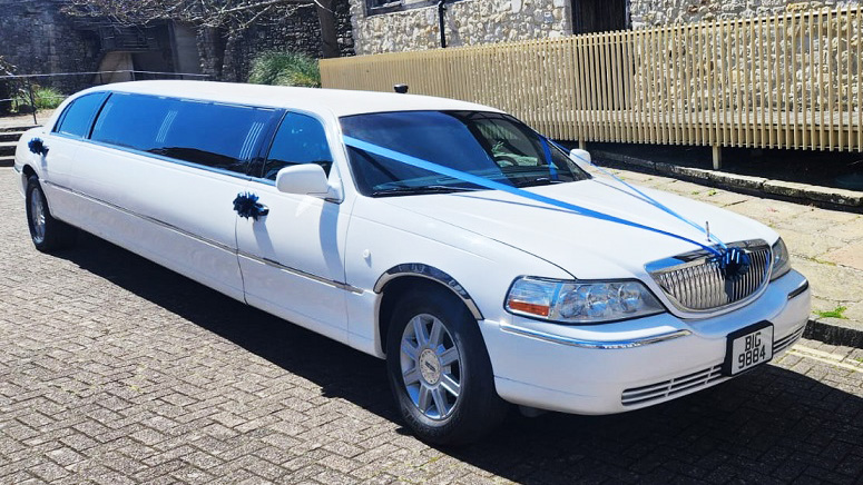 Right side view of an American Lincoln Town Stretched Limousine with Blue ribbons and bows