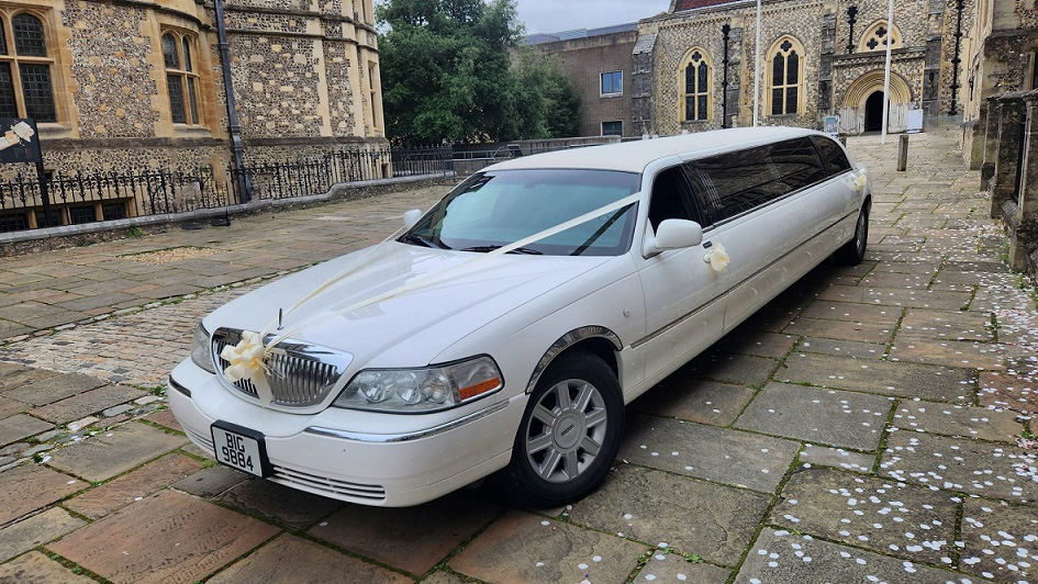 White American Stretched limo with gold wedding ribbons