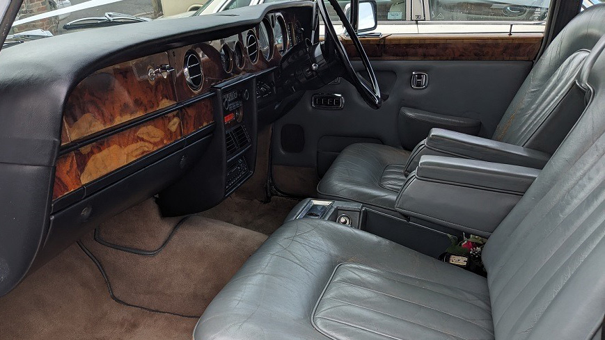 front seats in dusty blue leather taken front the passenger's side, wooden dashboard,