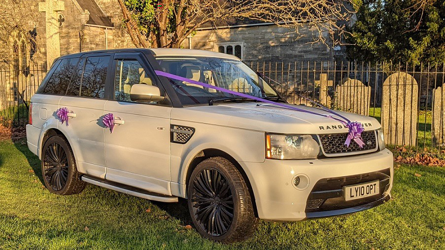 White range Rover with Black Wheels decorated with Purple Ribbons and bows