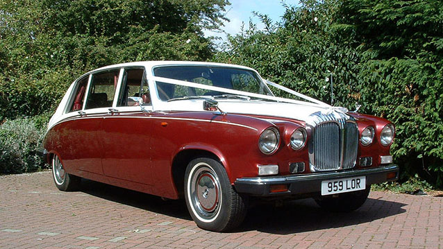 Burgundy & White Daimler Ds420 Limousine decorated with white wedding ribbons