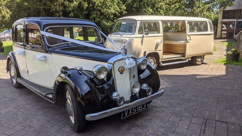 vintage Rover p3 dressed with lillac ribbons and a classic ampervan in the background