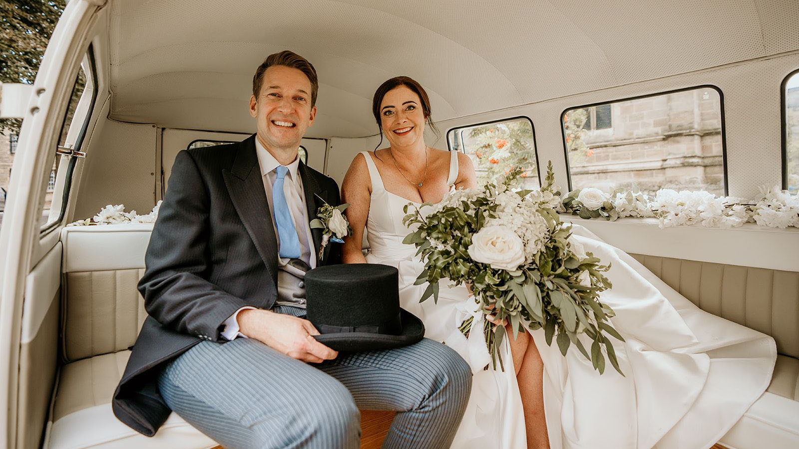 Bride and groom seating inside a vw campervan