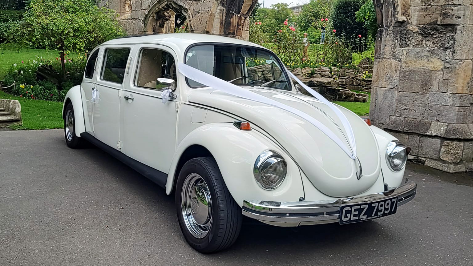 Classic Volkswagen Stretched Beetle Limousine decorated with white ribbons