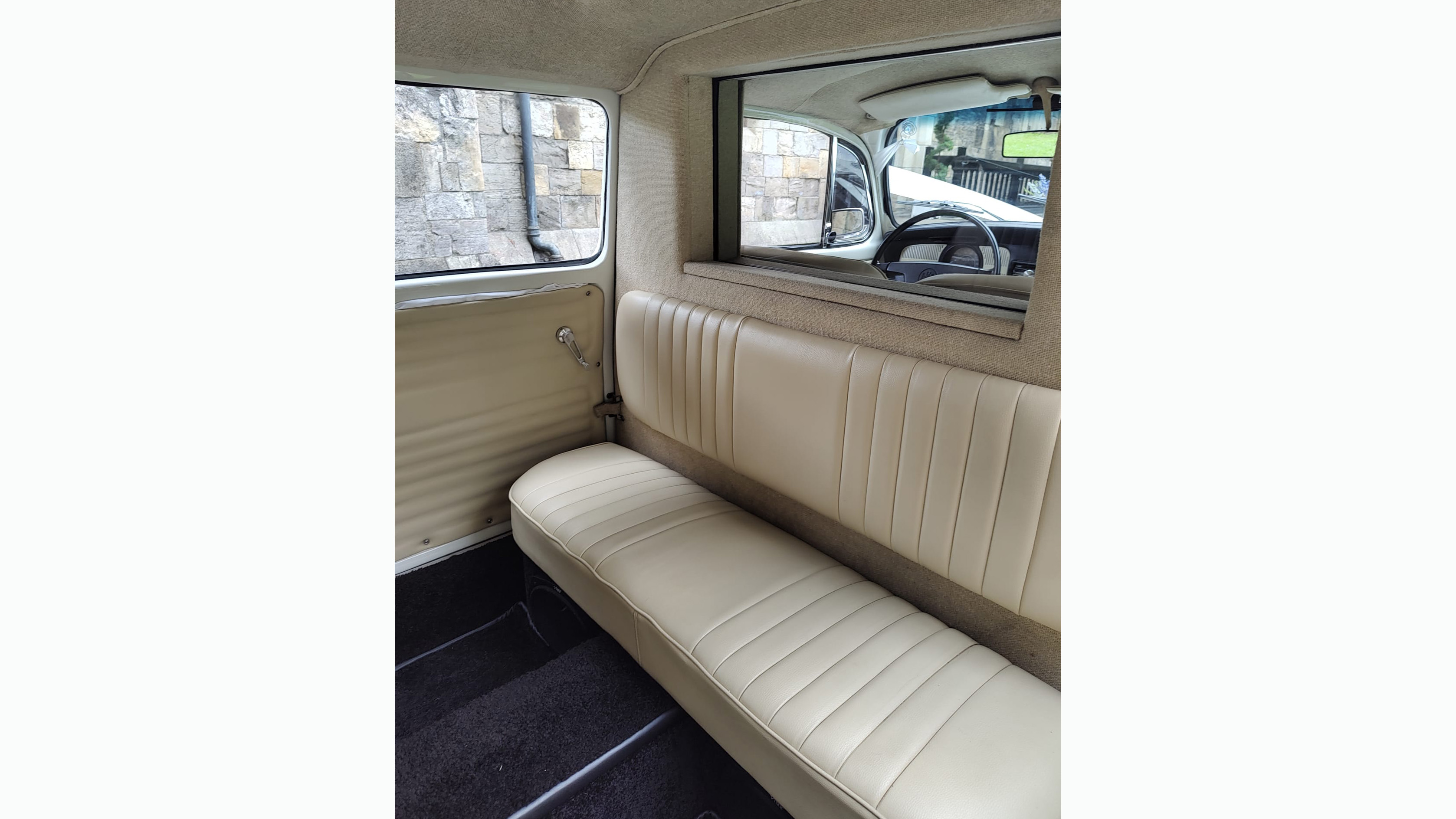 interior cream leather seat inside stretched beetle with glass division between rear passengers and chauffeur.