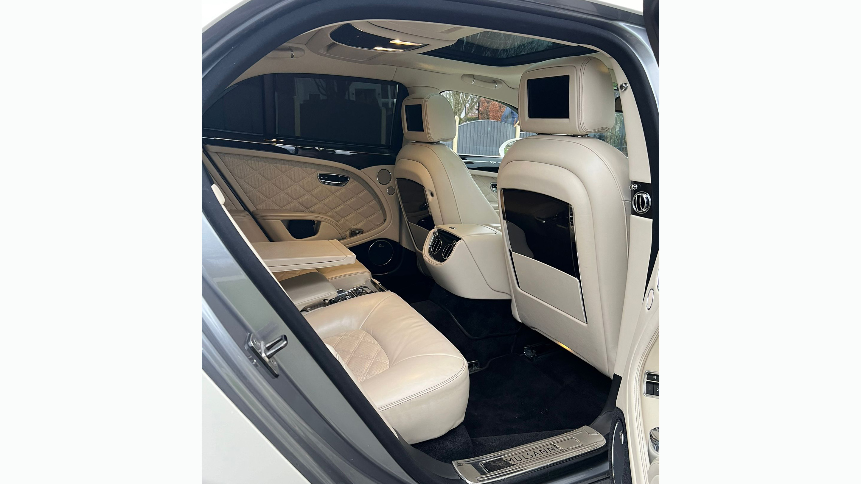 Rear interior in cream leather, TV in headrests, and  wooden picnic table