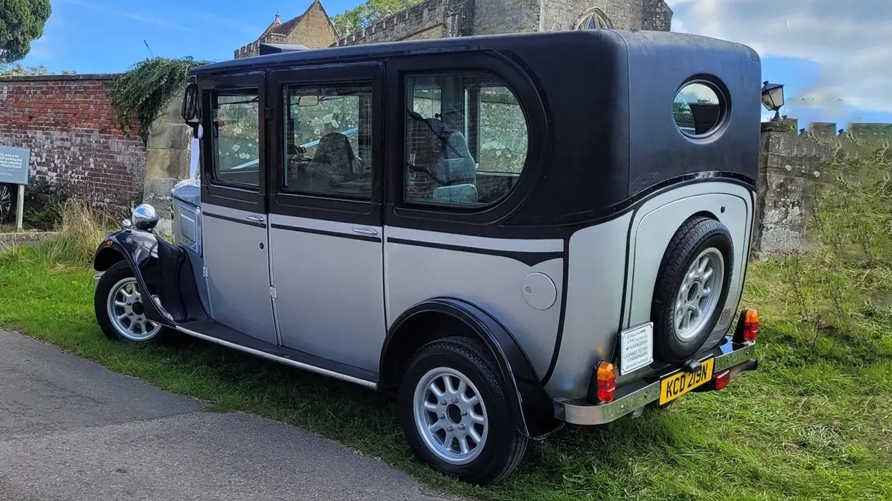 Rear view of a silver and Black Asquith Taxi vintage taxi style with spare wheel mounted at the rear of the vehicle