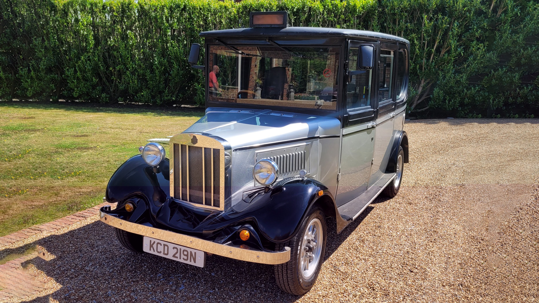 Front view of a vintage style taxi replica in Silver and Black with Taxi sign on top of the ehicle