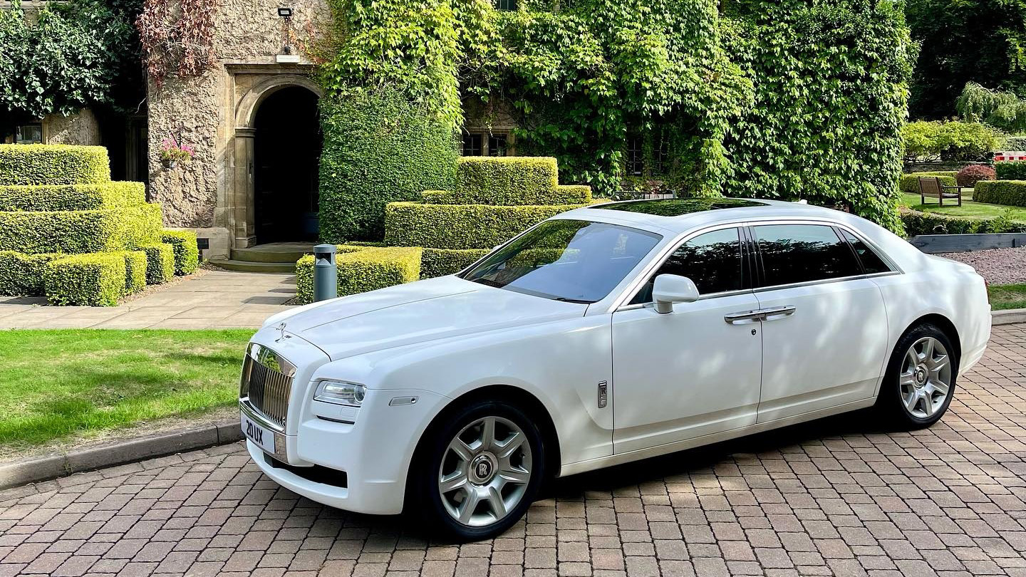 Left side view of white Rolls-Royce Ghost with blacked out rear windows