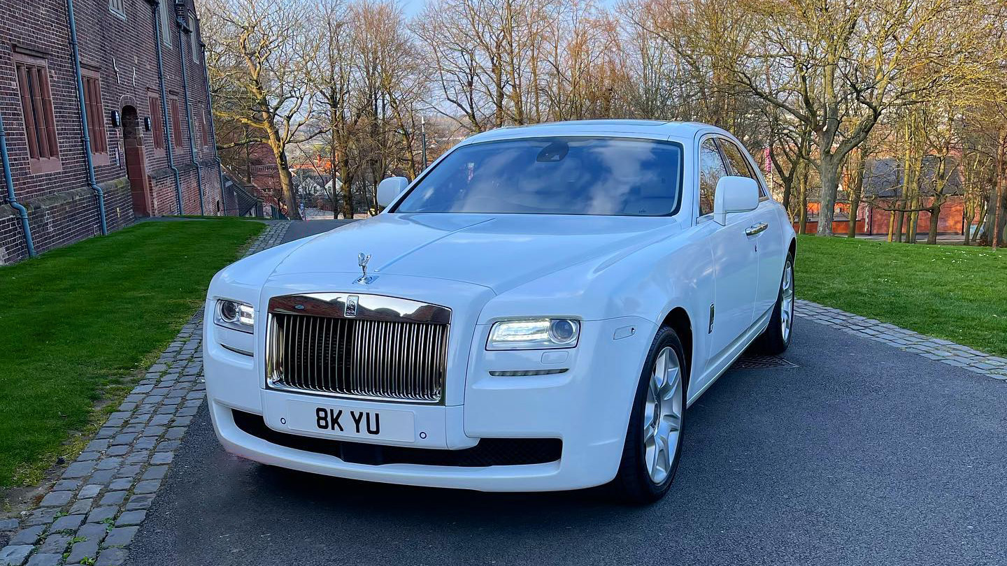 Front view of Rolls-Royce Ghost with headlights on