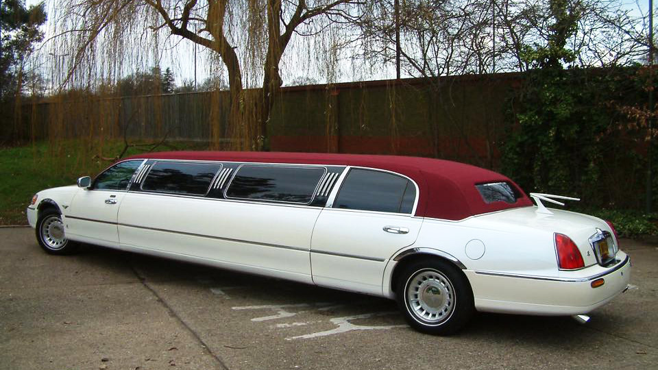 White stretched limousine with blacked out windows and burgundy roof