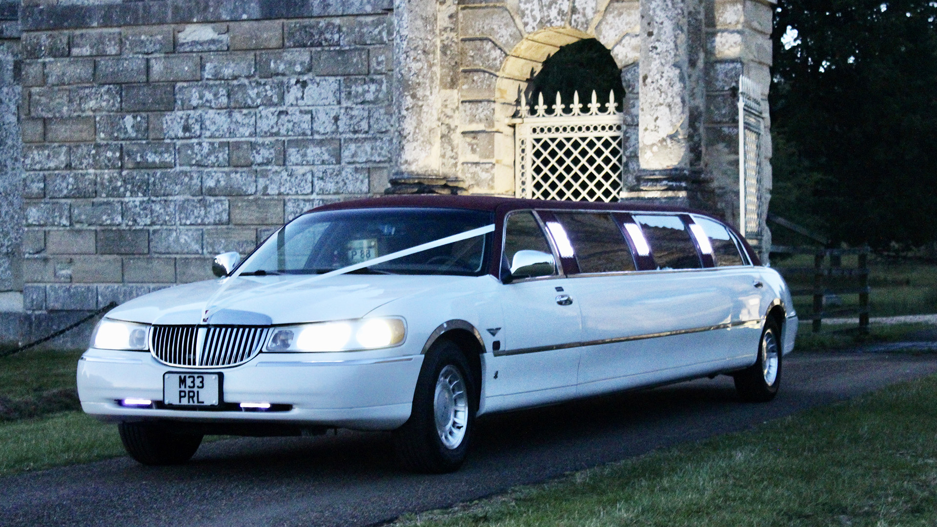 White limousine with wedding ribbons