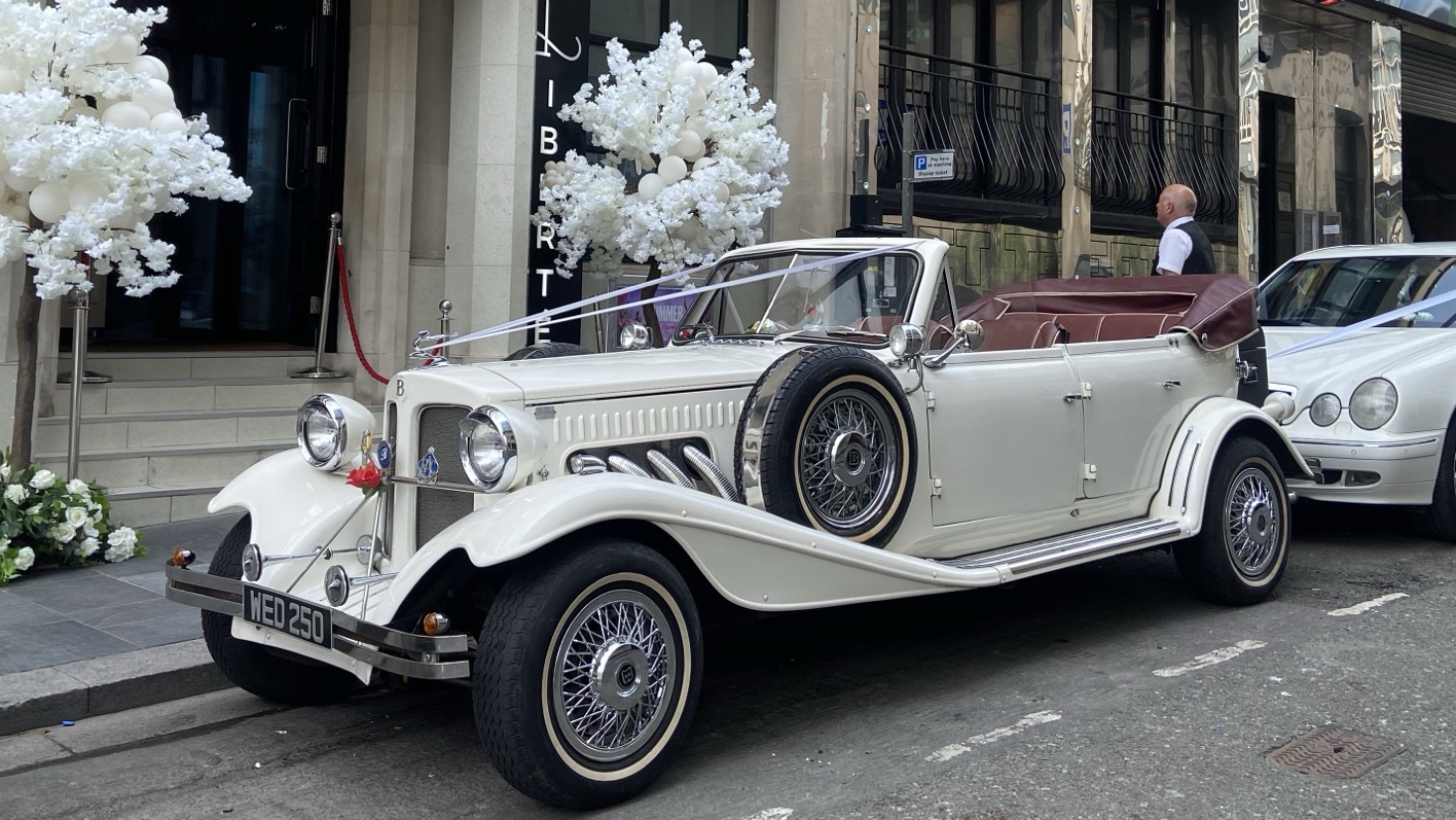 Convertible Beauford with roof down parked in front of a wedding venue in Liverpool  showing a Marroon leather interior