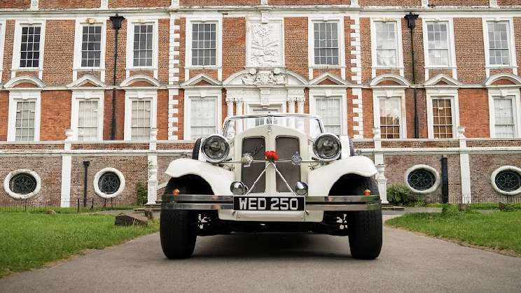 Full front view of a vintage style Beauford with Red flower attached to the front grill