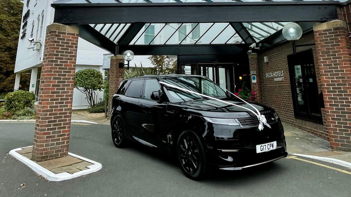 Black Range Rover decorated with white ribbon and bows in front of Marriot Hotel in Yorkshire