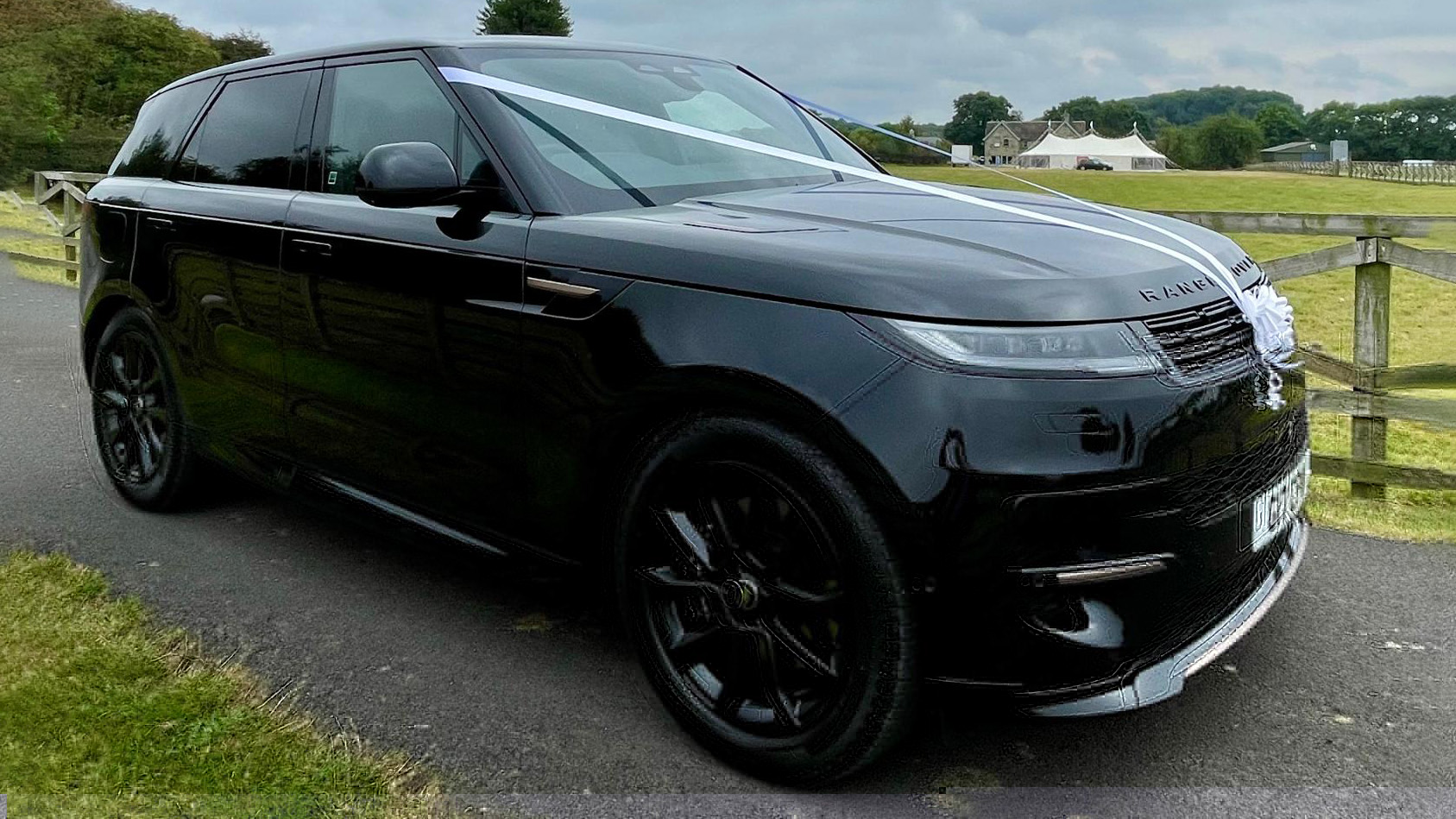 Black Alloy wheels on a black Range Rover with White Ribbons accross front Bonnet.