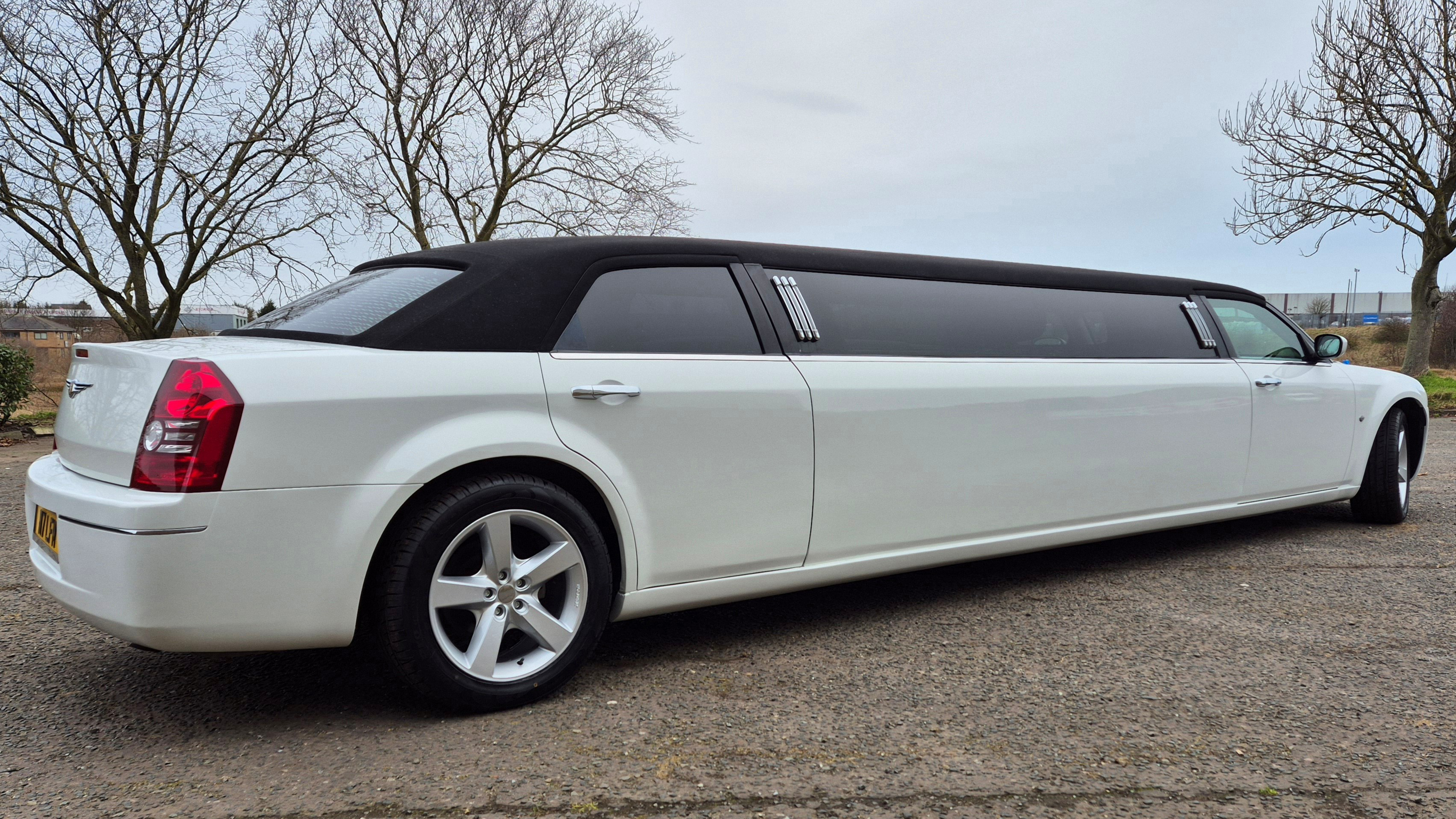 Rear view of a white American stretched Limousine with black roof