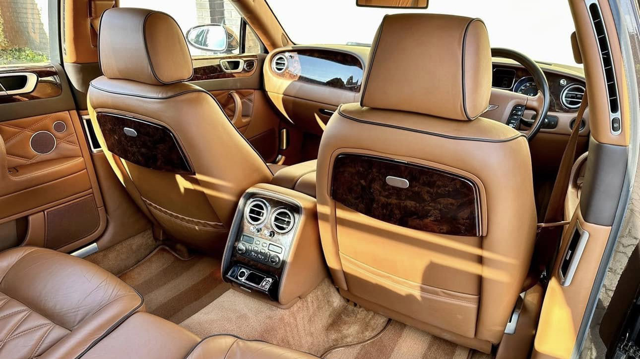 Tan Leather rear interior in Bentley Flying spur with wooden picnic table